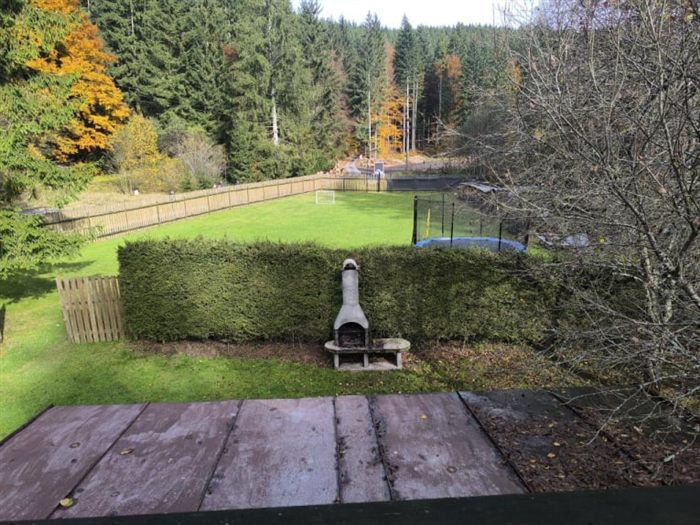 Výhled na zahradu s trampolínou